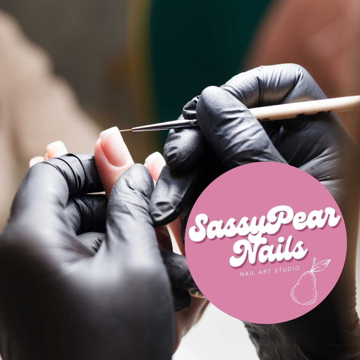 The Sassy Pear Nails circular logo placed over a photo of gloved hands painting a nail with a fine brush